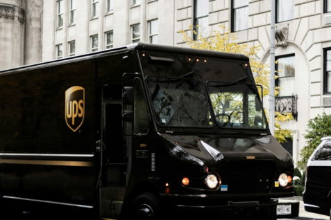 a ups truck driving down a city street